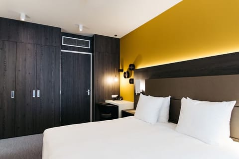 Drift off in a sleek room with warm, golden glow.