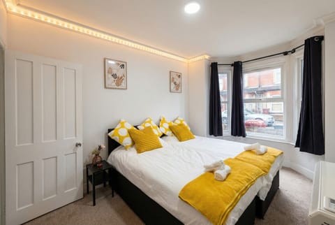 Sink into crisp white linens under warm LED mood lighting in this bright double bedroom with a classic bay window.