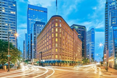 Arrive to an iconic downtown landmark glowing at blue hour.