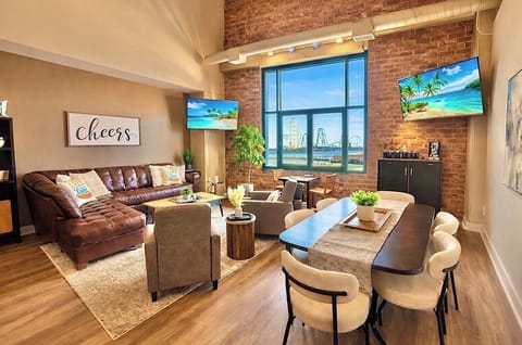 Unwind in this bright, loft-style living space where city views, cozy seating, and dual TVs set the mood—whether you're chasing sunsets, movie nights, or a laid-back escape.