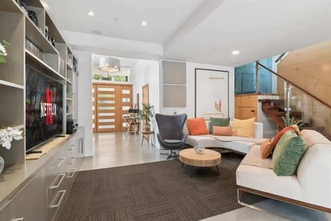 The beautiful and sun-soaked living room with designer furniture and a huge TV.