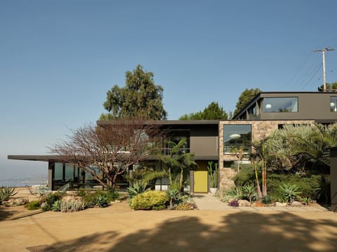 The full picture mid-century masterpiece perched above the Pacific, with ocean views and that iconic chartreuse door.