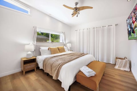 Spacious bedroom with vaulted ceilings, soft lighting, and a plush king bed.