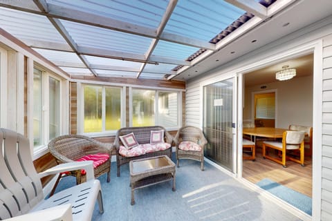 Bright enclosed patio with comfortable seating, perfect for relaxing year-round.
