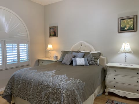 Queen white bedroom with its own private TV.
