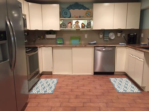 Many cabinets filled with spices, condiments, dishes, glasses, pots and pans.