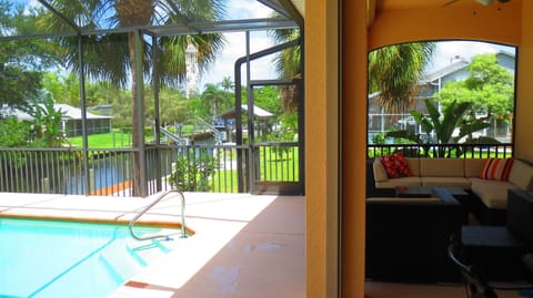 View of canal, pool and lanai with comfortable seating