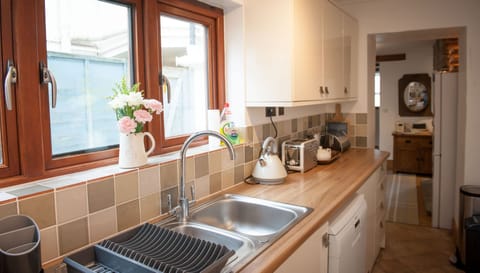 Kitchen window overlooks the path leading to the garden with tall fence separation from neighbouring property.
