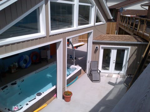Upper deck view of pool patio area, Doors are open so the sun shines on the pool