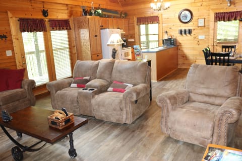 Living room with new hardwood floors, dining table, and full size kitchen