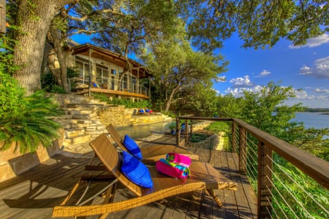Pool/spa/decks built into the hillside banks of Lake Travis among the trees.