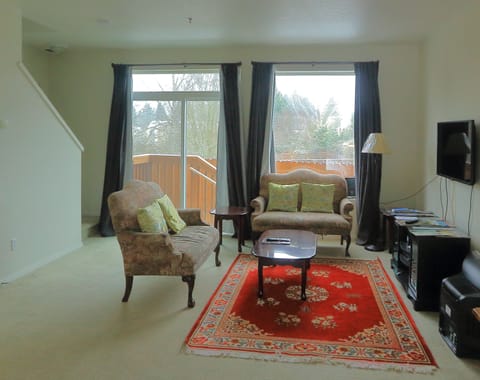 Spacious living room with entertainment console and a patio.