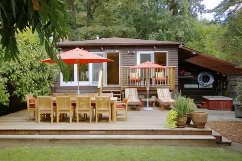 The terrace, balcony, main house, and hot tub on the right.