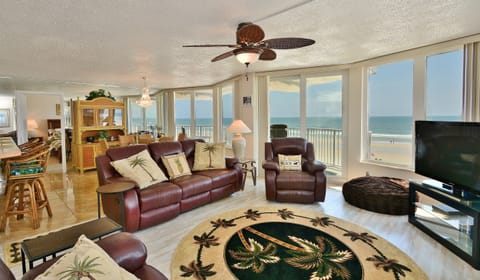 Sit in the living room with panoramic views of the ocean and beach.