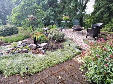 Open patio, fire pit and rock garden off of covered patio