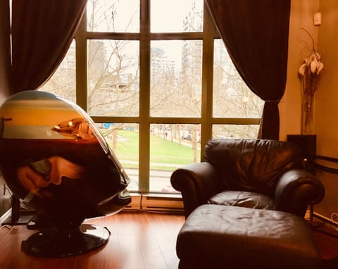 Living room floor to ceiling windows overlook park with Salvador Dali Egg chair