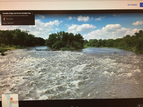 Cabin on bluff of Big Sioux River with rushing waters of the Klondike Dam below. House in Iowa