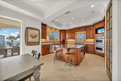 This Huge Kitchen Features Double Wall Ovens, A LArge Fridge and Freezer Combo and 5 Burner Stove Top All Surrounding The Massive Kitchen Island