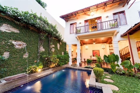 Tropical courtyard and 40' pool at dusk.  Master bedroom balcony overlooks pool