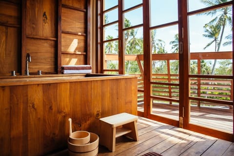 Upstairs master bath teak soaking tub overlooking the ocean