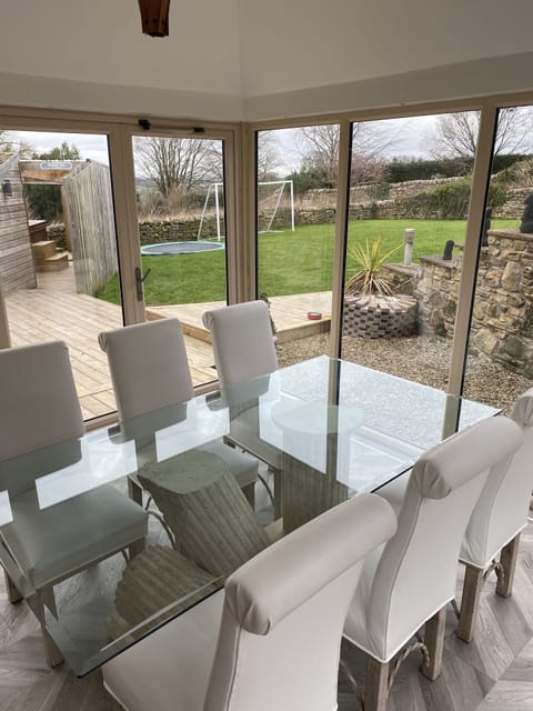 Sun lounge dinning table. Bi-fold door to garden/decking area