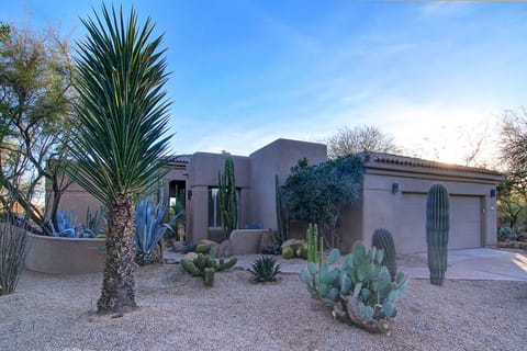 Front Entrance of the property with two-car garage, offers desert landscaping