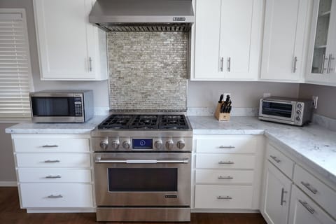 Chef's kitchen with modern appliances and marble countertops