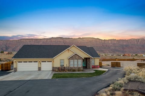 Front View of home and the Moab Rim in the evening. Displays ample parking  also