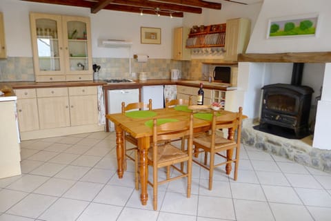 fully equipped farmhouse kitchen with stove and dining area