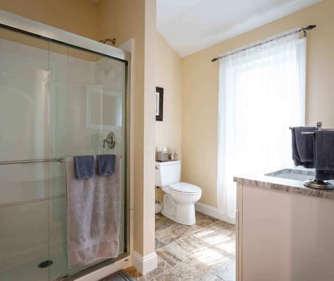Full-sized bathroom with spacious, easy step-in shower and marble countertops.