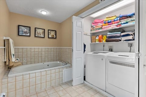 Bathtub, rainfall showerhead, hair dryer, towels