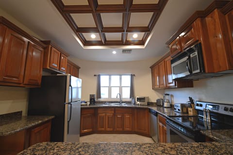 Gourmet kitchen featuring Cusinart stainless appliances & granite.

