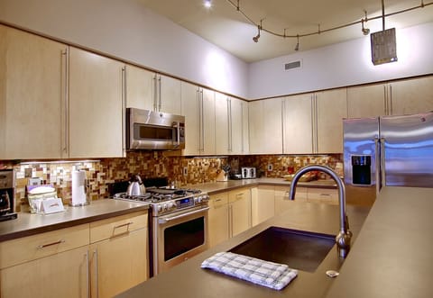 Stainless steel, glass tile backsplash, stone countertops and STOCKED kitchen.