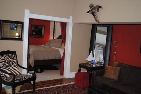 The bedroom adjoins from the living room. Walls have vivid colors and art work.