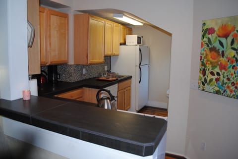 Well appointed kitchen with chefs knives, wine glasses, cutlery, pots and pans