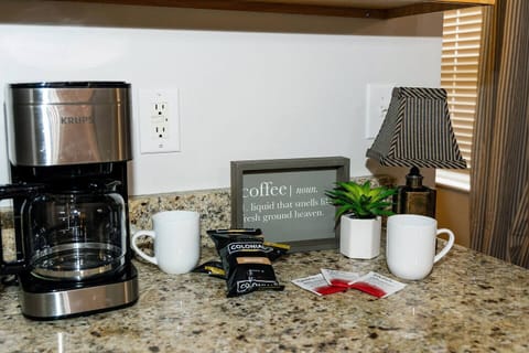 Krups drip coffee maker with coffee, creamer, sugar, and tea on us.