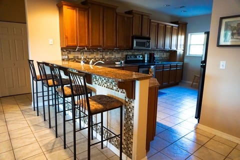 Kitchen with ceramic tile floors, stainless appliances, and counter for four