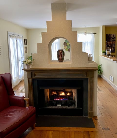 Gas-log fireplace located in the living room with dining room on other side.