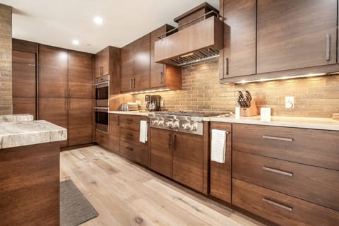 The fully equipped kitchen boasts a 6 burner Wolf gas stove with hood system and double oven.