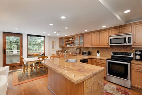 Stainless steel appliances, granite countertops, custom made dining table and a great view are found in the kitchen/dining area.