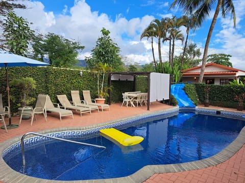 Large pool terrace with lounge chairs and garden table for ten people and gazebo