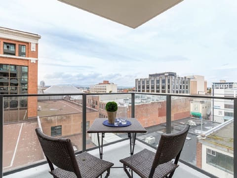 Chic balcony retreat with city skyline views and cozy seating
