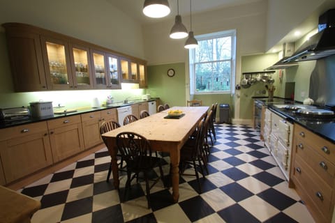 The modern kitchen has an AGA and electic rangecooker and plenty of cookware
