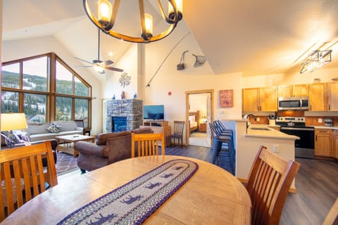 Living area featuring hardwood flooring, vaulted ceilings, ample seating, gas fireplace, flat screen TV and access to the private balcony.