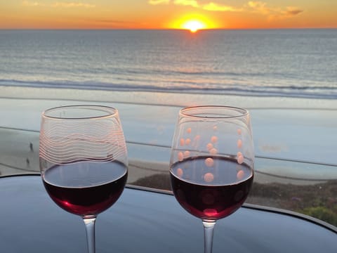 Two glasses of wine on a table overlooking the Pacific Ocean