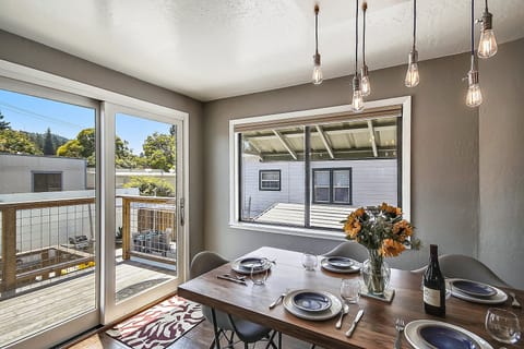 Light and bright dining space opens to the back stairs and overlooks the pool.