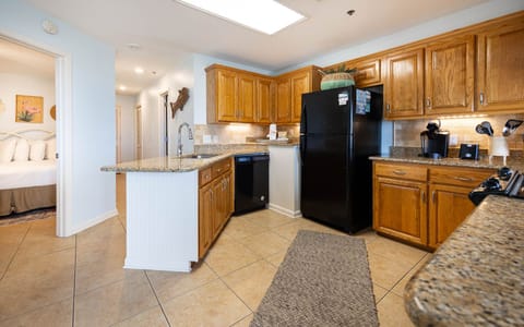 The kitchen features wooden cabinets, a black refrigerator, Keurig coffee station, and a breakfast bar area