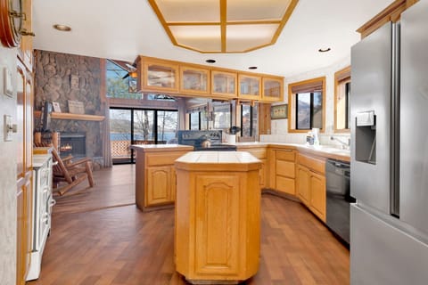 A beautiful spacious kitchen with a refrigerator, stove, microwave, oven, toaster, coffee machine, blender, dishwasher, and breakfast bar to enjoy a delicious meal.