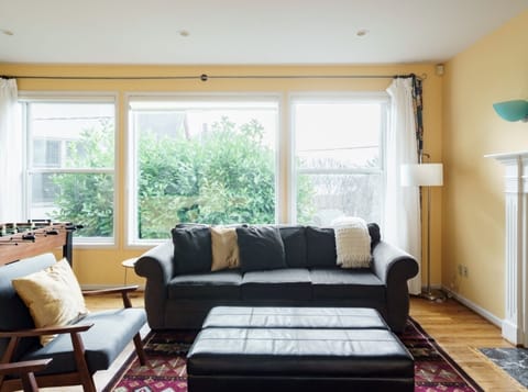 Spacious living room has expansive windows opening towards the water view
