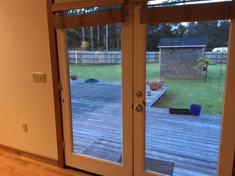 View of spacious enclosed backyard across huge redwood deck.